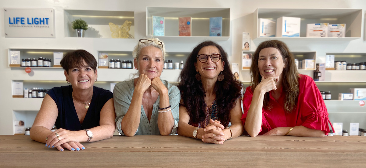 Mitarbeiterinnen des Kundenservice stehen nebeneinander und lächeln in die Kamera