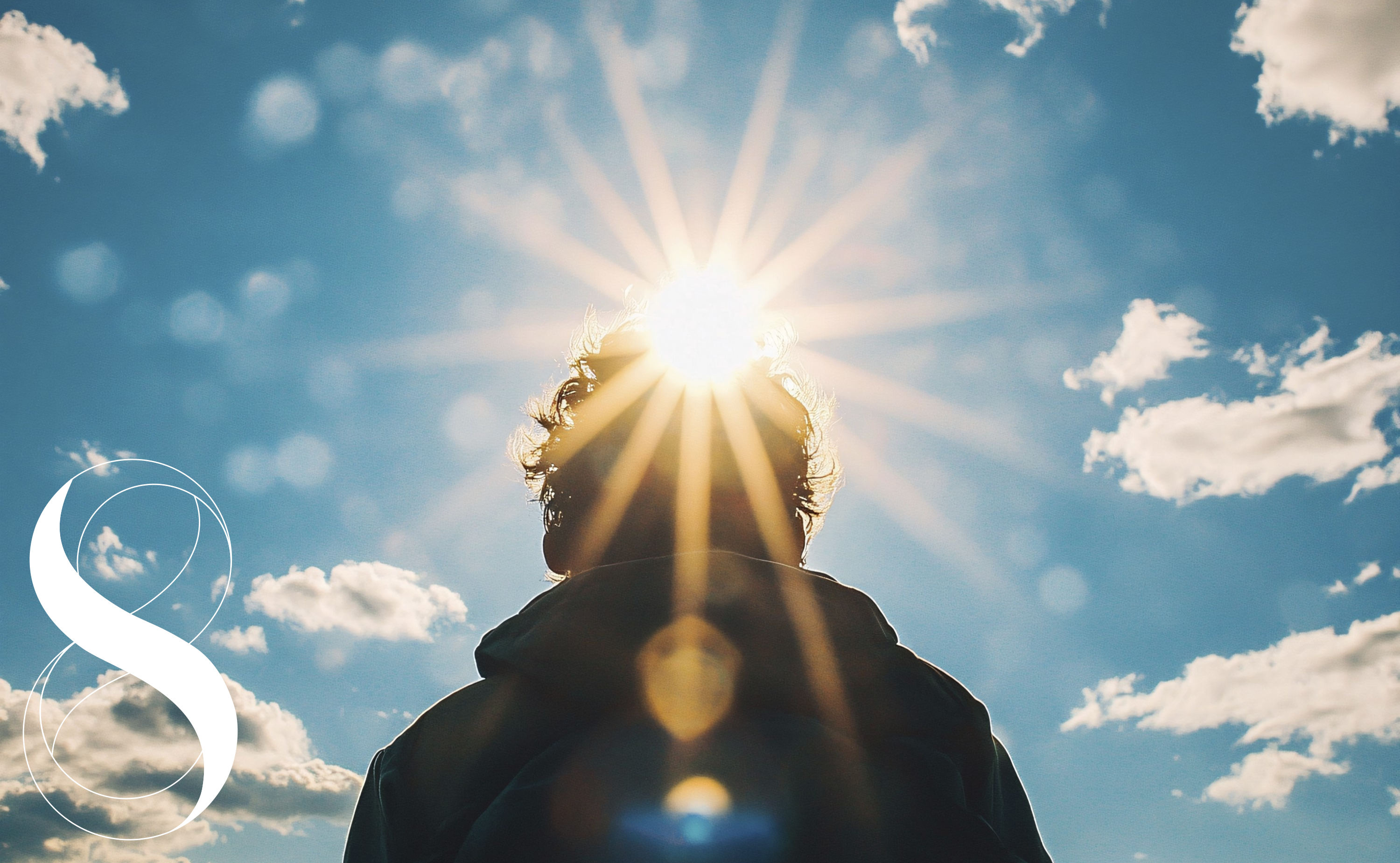 Rückenansicht eines Menschen, dessen Kopf im Gegenlicht der hell strahlenden Sonne steht. Die Szene symbolisiert Vitamin D, Sonne und das Immunsystem.